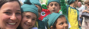 Eine Freiwillige hat Spaß mit kostümierten Kindern.