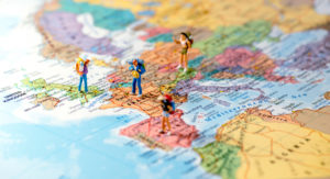 Spielfiguren mit Rucksack stehen auf einer Europalandkarte