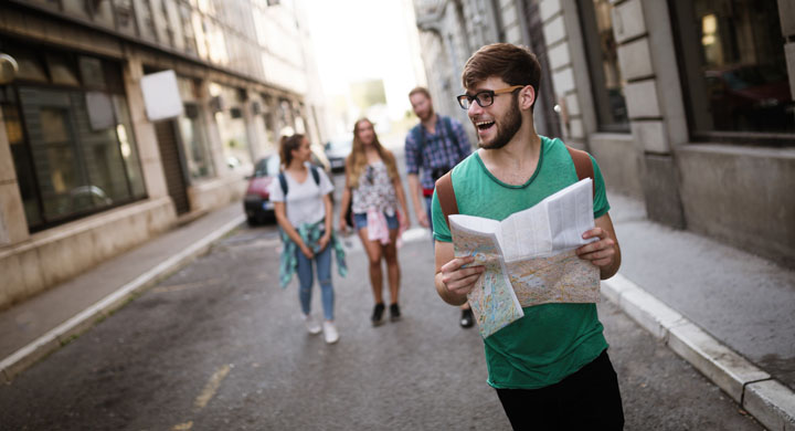 Junger Mann mit einem Stadtplan in der Hand