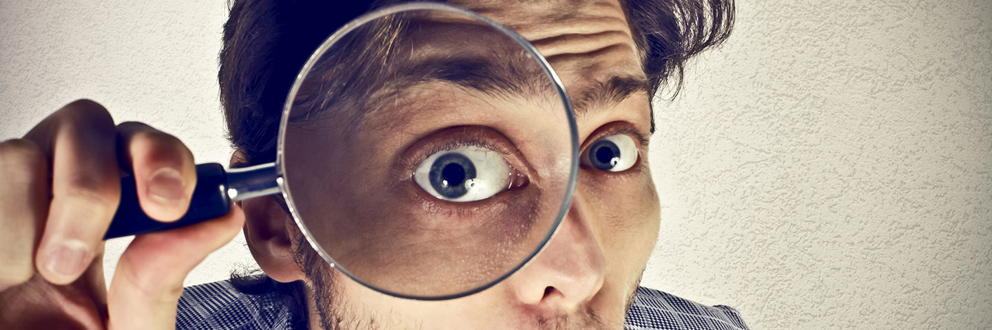 Businessman looks through a magnifying lens